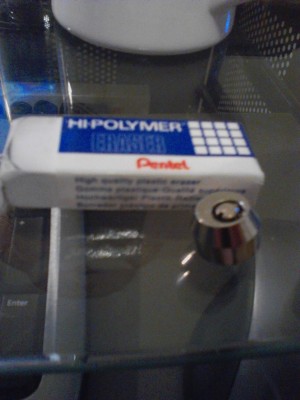 Tiny lil lock, placed next to a standard gum eraser