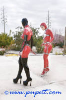 Photo of Pupett in a latex catsuit and a chastity belt