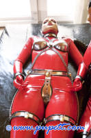 Photo of Pupett in a latex catsuit and a chastity belt